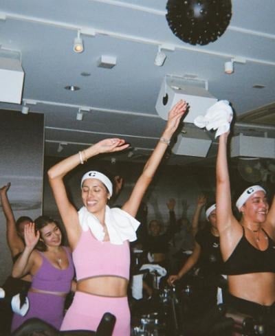 A cycling class with arms in the air
