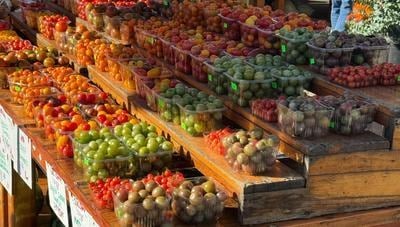 A farmers market stall piled with produce